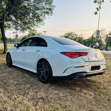 Mercedes-Benz CLA 200 sport back coupe sedan , ultimate AMG sport package 
1.6 cc twin turbocharged with 10 speed triptonic transmission.
Model 2021 registered Punjab 2022
Shahnawaz Pakistan import 
Mileage 18500 km
First owner vehicle 
Diamond white metallic colour with black two tone Dezine line AMG interior.
Bumper to bumper original condition & spotless.
Top of the line specs & customised options.
Glass panoramic electric sunroof 
Two tone leather AMG bucket seats
Multi power & 11 zone adjustment seat 
Heated & ventilated seats
8 zone climate control air conditioning 
Full dashboard single line  led cluster display.
64 colours ambient interior lighting 
Burdmaster pro premium surround sound system 
Multi 360 degree cameras 
Auto pilot 
Apple CarPlay & android apps
Electric multi zone massager seats 
Perfume air package 
Adapted Radar 
Adapted cruise control 
Line assisted & blind spot monitor 
Privacy glasses package 
All zone parktronic sensors access 
AMG suspension & break
Full AMG body kit
19” AMG alloy wheels 
Duel AMG mufflers
Further information please call & visit at Victory Cars Lahore.